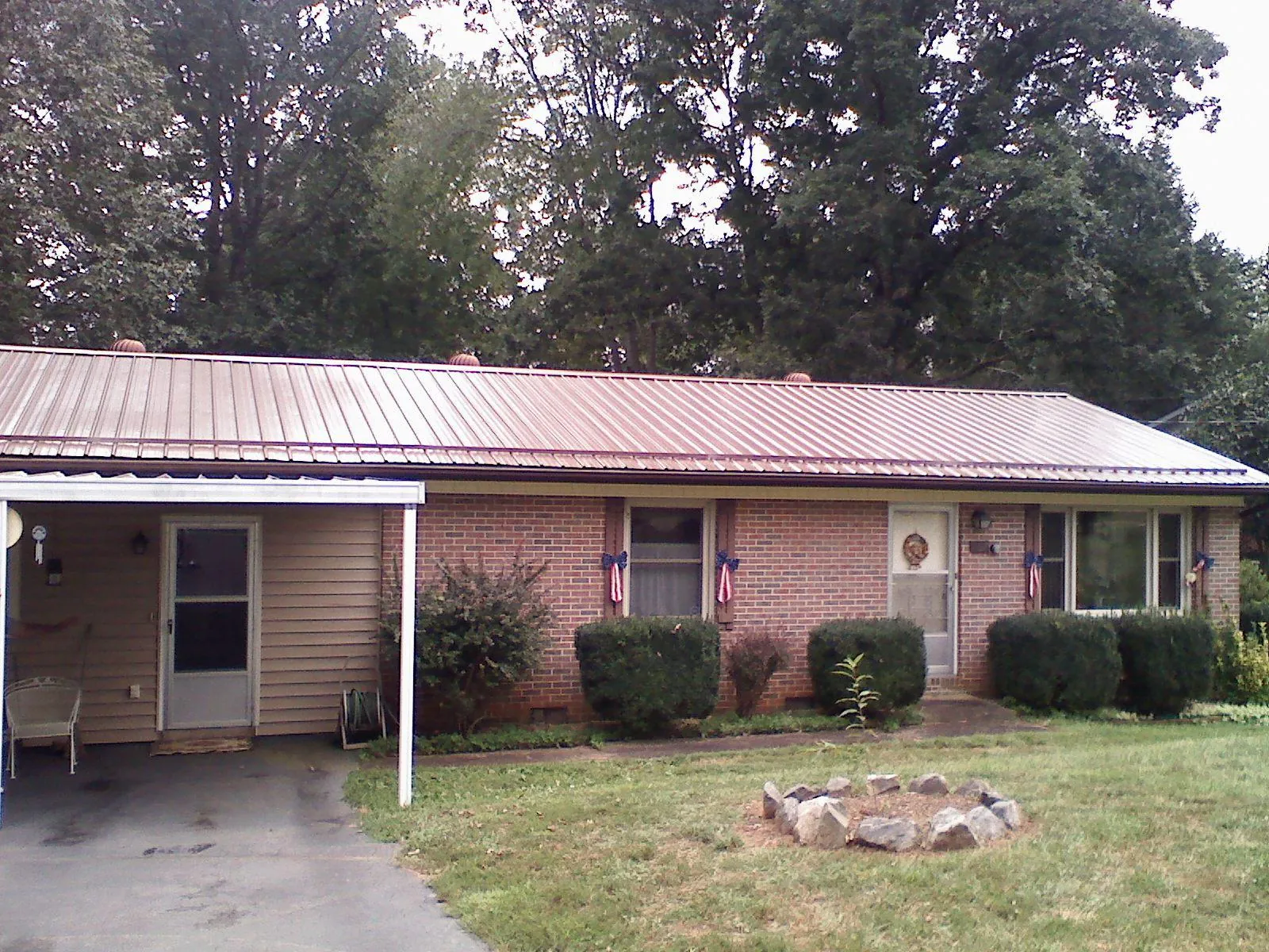 Bronze metal roof and carport on a brick ranch home — Roof Repair work by our crew in Sauk Rapids